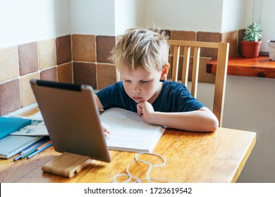 Schoolboy Doing Homework Looking At A Lesson On A Laptop Screen In Zoom. Student In Online Tutoring. Distance Learning. E-learning