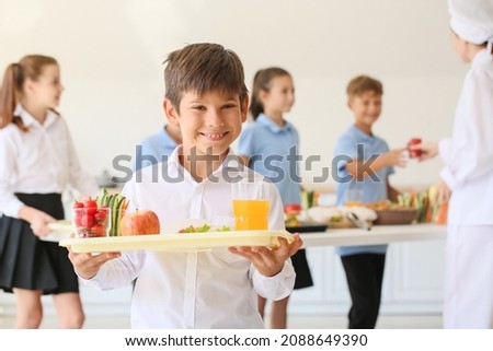Schoolboy having lunch in school canteen