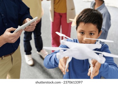 Schoolboy helping teacher launching quadcopter via tablet computer - Powered by Shutterstock