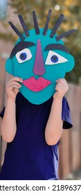 Schoolboy Holding Mask Of Picasso Painting In His Hand.