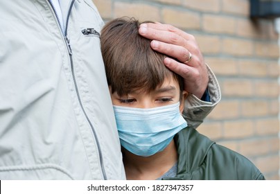 A schoolboy in a medical mask. A father comfort a son, depresson, being sad and lonely because of Coronavirus, Covid-19. love from a father to a son family together