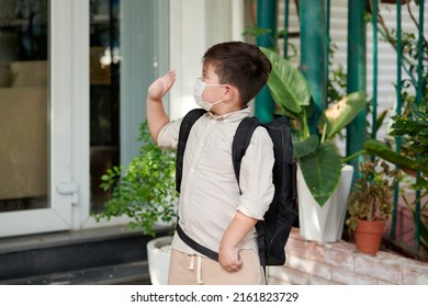 Schoolboy In Medical Mask Waving With Hand When Leaving House For School