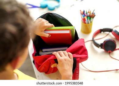 schoolboy puts office supplies in a backpack. Preparing for school. Back to school. Self-assembly of a school backpack. Close-up - Powered by Shutterstock