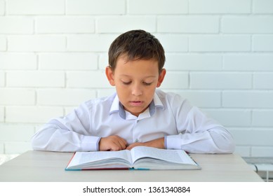 Schoolboy reading a book and learning a verse