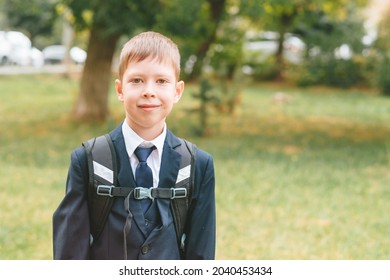 A Schoolboy In A School Uniform And A Backpack Stands On The Street. Boy In School Uniform. Back To School Concept And No Desire To Study