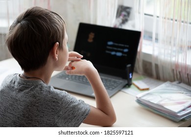 A Schoolboy Studies On A A Laptop At Home In A Country House Using Remote Technologies During Self-isolation. Online Training, Home Education, Headphones, Stay At Home