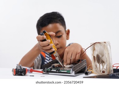 Schoolboy studying Robotic and electronic components at home - Powered by Shutterstock