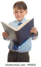 Schoolboy in uniform reading from a blue book