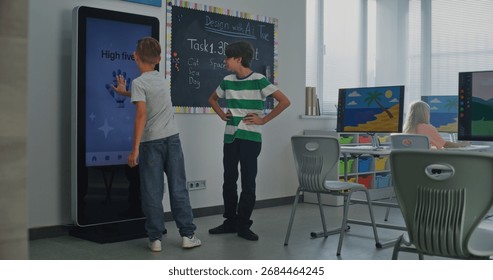 Schoolboy Uses Interactive Digital Screen, Talks Classmate. Boys Study STEM Classroom. Concept Of Integrating Educational Technologies, Social-emotional Learning Into Modern Education. Dolly Shot.
