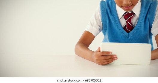 Schoolboy using digital tablet against white background