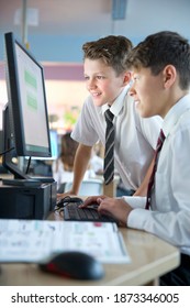 Schoolboys In Private School Uniform Sharing Computer In The Computer Lab