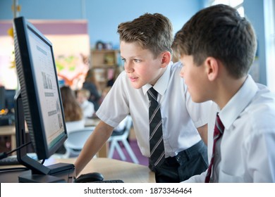 Schoolboys In Private School Uniform Sharing Computer In The Computer Lab