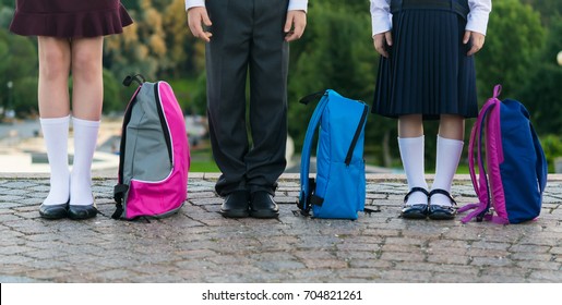 Schoolchildren With Backpacks Stand In The Park Ready To Go To School, Long Photo