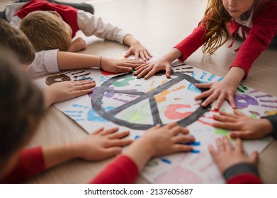 Schoolchildren making poster of peace sign at school. - Shutterstock ID 2137605687