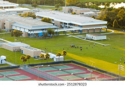 Schoolchildren playing American football game on campus stadium in sports park - Powered by Shutterstock