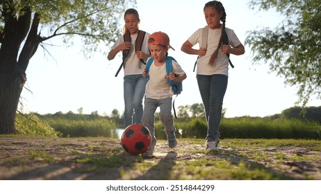 Schoolchildren playing a game of ball in their backpacks. Kid sport boy concept. Group of kids playing soccer at school. Group of kids playing soccer in their lifestyle backpacks with schoolchildren. - Powered by Shutterstock