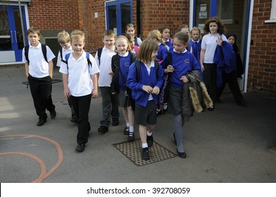 SCHOOLCHILDREN AT A SILCHESTER SCHOOL HAMPSHIRE ENGLAND UK - CIRCA 2013 - Schoolchildren In The Playground Leaving The School After Lessons Had Finished