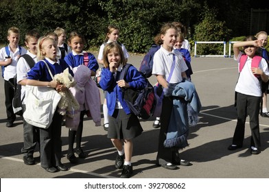 SCHOOLCHILDREN AT A SILCHESTER SCHOOL HAMPSHIRE ENGLAND UK - CIRCA 2013 - Schoolchildren In The Playground Leaving The School After Lessons Had Finished