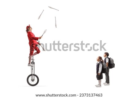 Schoolchildren watching an acrobat riding a giraffe unicycle and juggling isolated on white background
