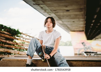 Schoolgirl after lessons at skateboarding practice in outdoor skate park. Stylish and beautiful caucasian girl with skateboard on a half pipe ramp in a skatepark. Teenager skater girl with skate deck. - Powered by Shutterstock