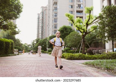 Schoolgirl Back To School After Summer Vacations. Child In Uniform Smiling Early Morning Outdoor. 