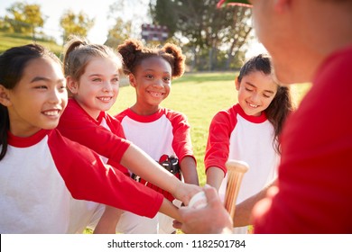 Schoolgirl Baseball Team In A Team Huddle With Their Coach