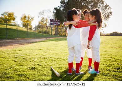 Schoolgirl baseball team talking in team huddle before game - Powered by Shutterstock