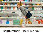 Schoolgirl with cart, shopping in stationery store