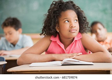 Schoolgirl daydreaming in classroom - Powered by Shutterstock