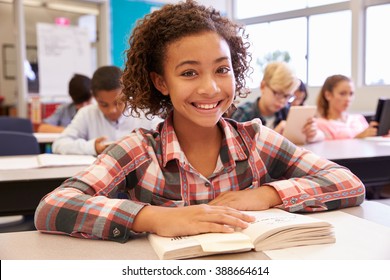 Schoolgirl At Desk In Elementary School Looking To Camera