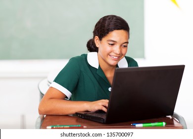 schoolgirl doing classwork using computer in classroom - Powered by Shutterstock