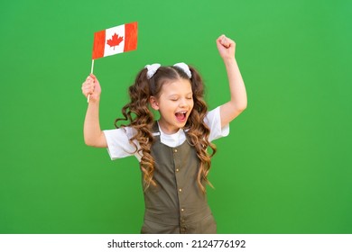 A Schoolgirl Holds A Canadian Flag And Rejoices. Kid Is Very Excited About Studying Abroad.