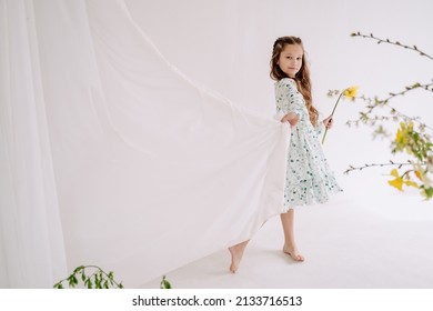 Schoolgirl Kid Holding Flower and Curtain in Room Looking at Camera Photo. Charming Girl Child Wearing Stylish Fashionable Hold Aroma Plant Bud Barefoot Walking Indoor Decorated Bouquet