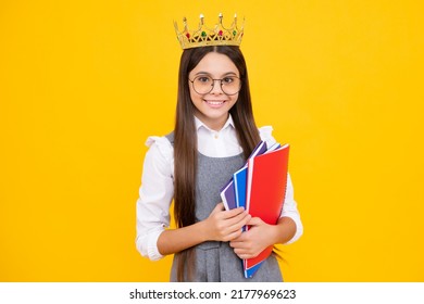 Schoolgirl nerd princess in school uniform and crown celebrating victory on yellow background. School child hold book. Education graduation, victory and success. Happy teenager school girl.
