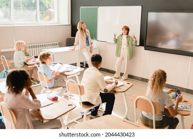 Schoolgirl pupil student answering at the blackboard, presenting project homework during class lesson at school. Teacher listening to student`s answer - Powered by Shutterstock