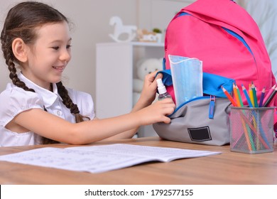 Schoolgirl puts sanitizer and mask into her backpack.Student safety after covid-19 pandemic. Back to school after coronavirus outbreak.Virus and disease prevention for kids. - Powered by Shutterstock