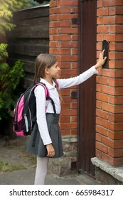 Schoolgirl With Rucksack Ringing In Doorbell