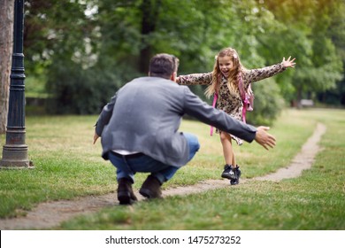 Schoolgirl Running To Dad To Give Him A Hug After School