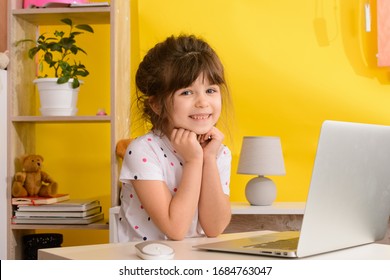 Schoolgirl studying homework during her online lesson at home, online education and online school concept, home schooler. Distance or remote learning