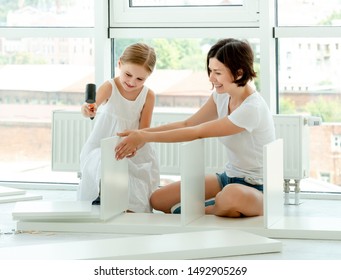 Schoolgirl Teen In Dress Is Helping Mother With Home Labor, Installing New Furniture