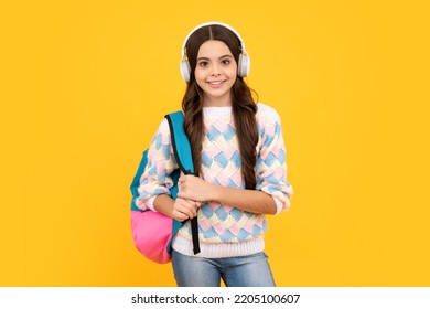 Schoolgirl, Teenage Student Girl In Headphones On Yellow Isolated Studio Background. School And Music Education Concept. Back To School.