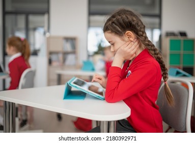 Schoolgirl using digital tablet during lesson in classroom at primary school. - Powered by Shutterstock