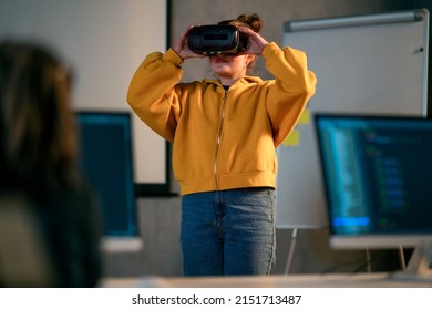 Schoolgirl wearing virtual reality goggles at school in computer science class
