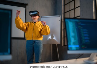 Schoolgirl wearing virtual reality goggles at school in computer science class