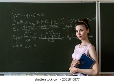 Schoolgirl Writing High School Maths Formula  With Chalk On Blackboard, Math Class Algebra