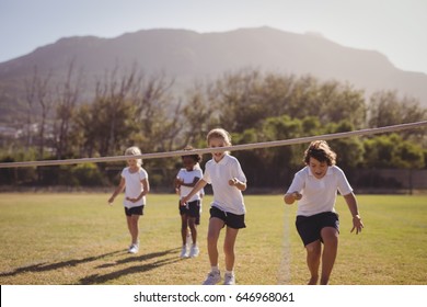 Schoolgirls running toward finishing line during egg and spoon race in park - Powered by Shutterstock