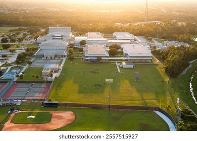 Schoolkids training in American football game on school stadium during physical exercise in North Port, Florida - Powered by Shutterstock