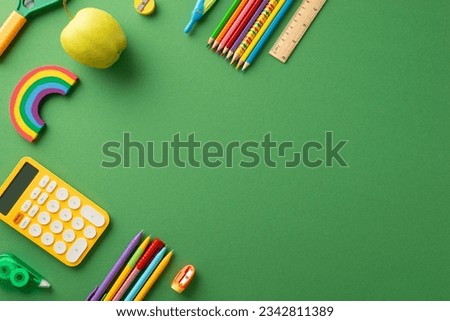 Schooltime essentials: A vivid top-view image of a green chalkboard displaying a delightful arrangement of educational stationary. Ample copy-space available for text or promotional messaging