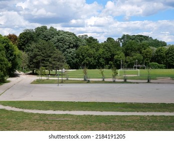 Schoolyard Sports Field With Outdoor Basketball Net And Soccer And Football Goal Posts.