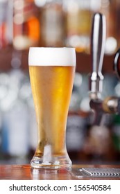 Schooner Glass Of Ice Cold Beer Sitting On Bar Top Near Beer Pouring Tap